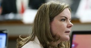 Gleisi Hoffmann de cabelo solto, de perfil, falando com expressão séria