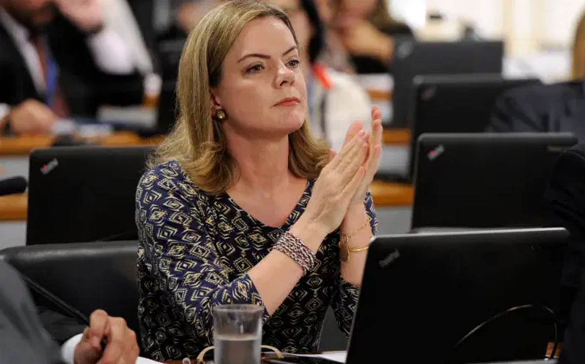 Gleisi Hoffmann com expressão séria e blusa estampada, de cabelo solto