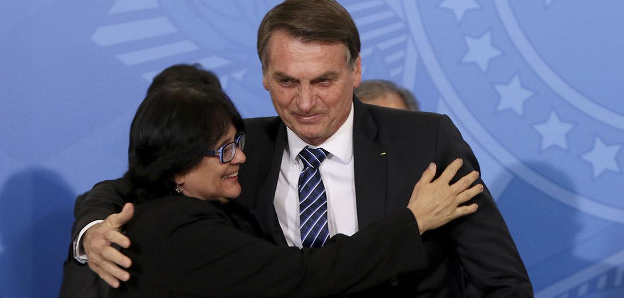 Damares e Bolsonaro se abraçando e sorrindo