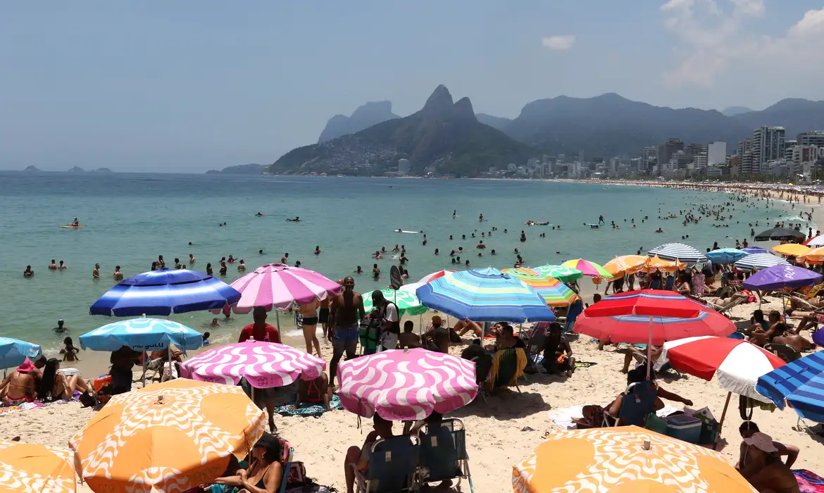 Praia carioca cheia de sombrinhas coloridas