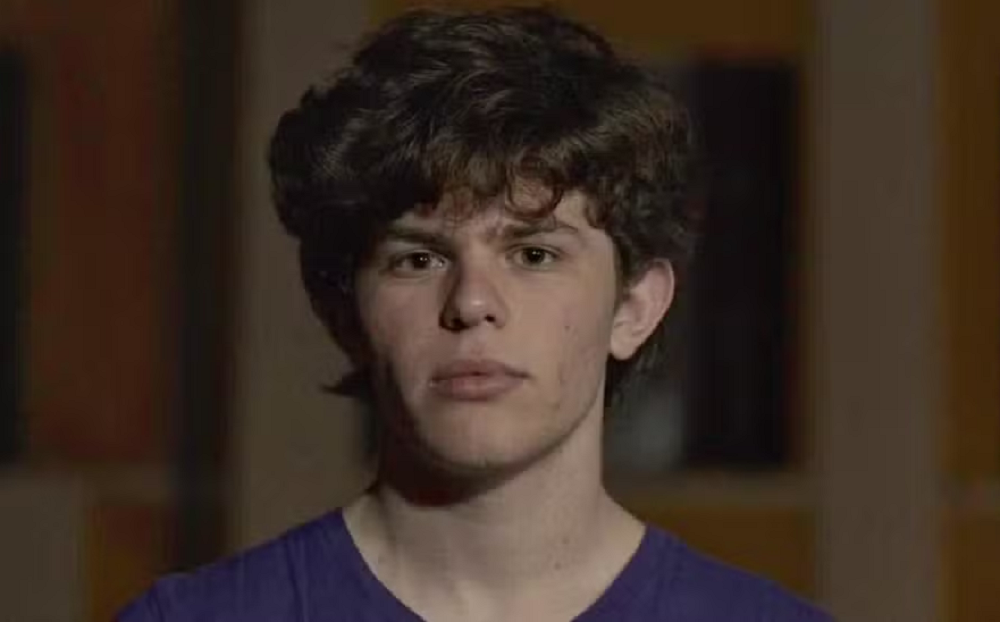 Tal Mitnick olhando para a câmera com expressão séria e camiseta azul