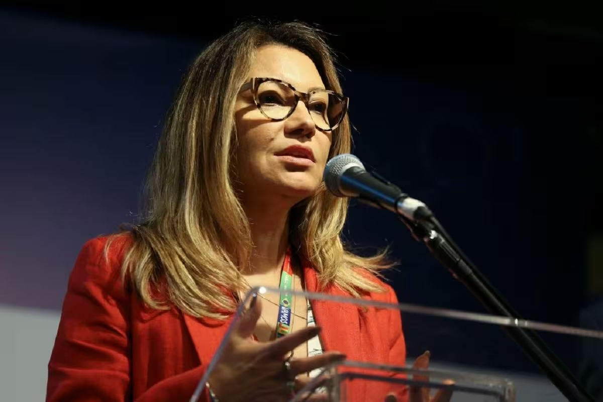 Janja de roupa vermelha e óculos, falando e gesticulando