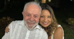 Lula e Janja sorrindo, abraçados, de roupas brancas