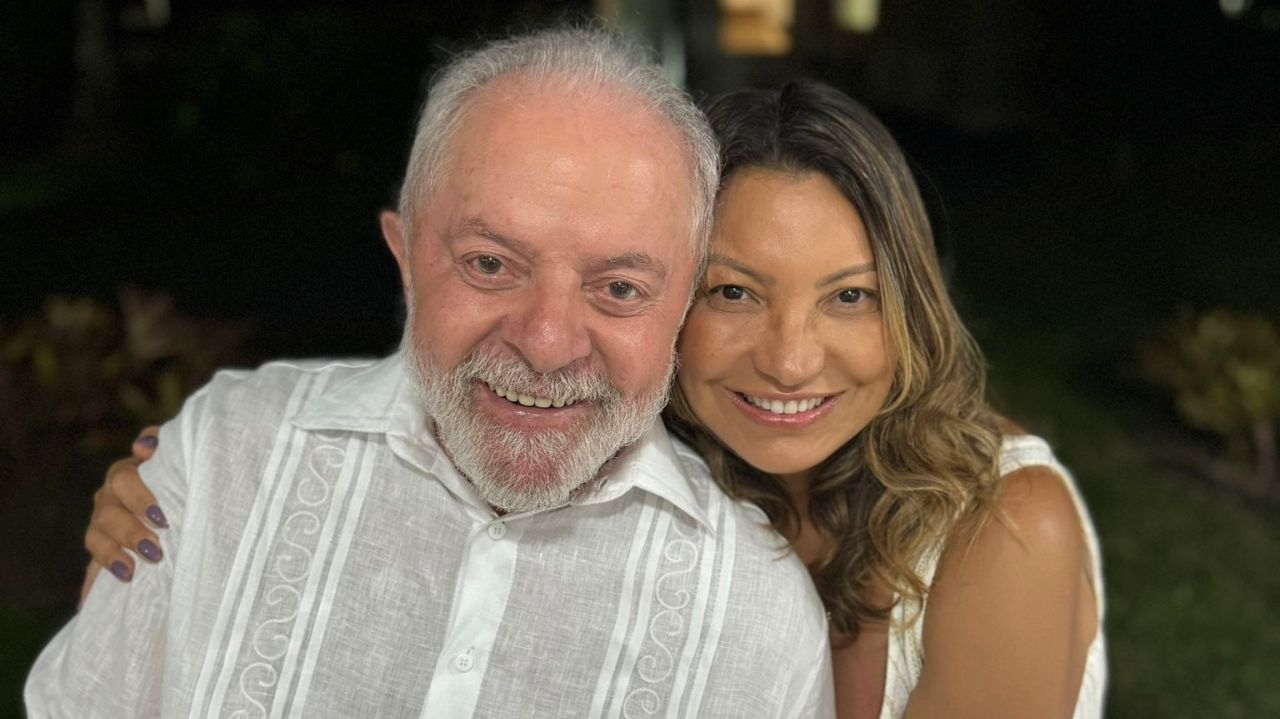 Lula e Janja sorrindo, abraçados, de roupas brancas