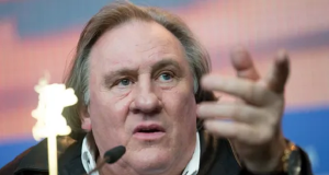 Gérard Depardieu com expressão séria, apontando pra frente