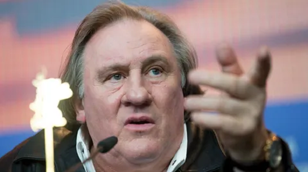 Gérard Depardieu com expressão séria, apontando pra frente
