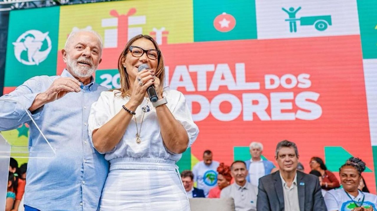 Lula e Janja sorrindo lado a lado em palco
