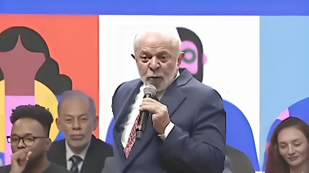 Lula falando em microfone em palco de conferência