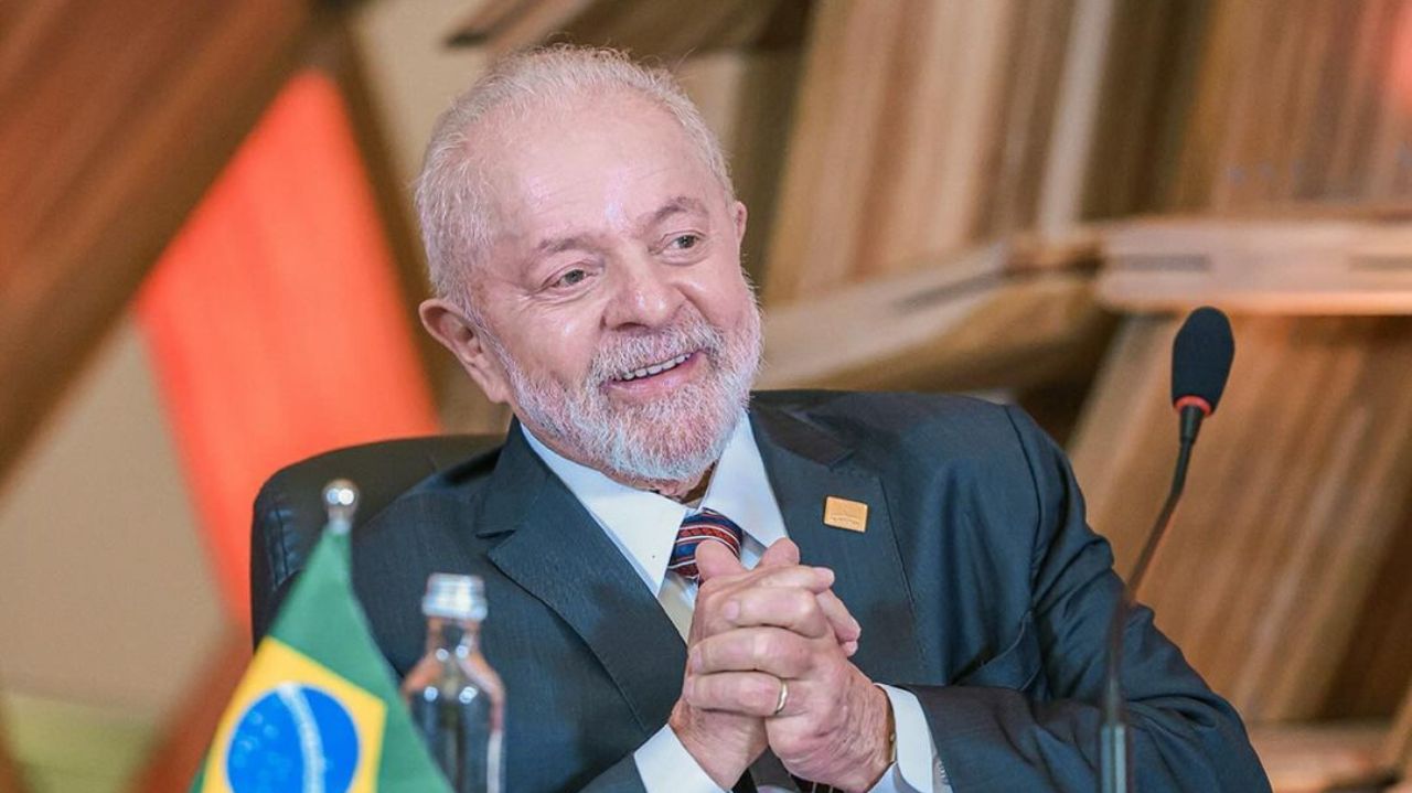Lula sorrindo e com mãos unidas