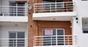 Fachada de prédio com anúncio de aluguel em espanhol