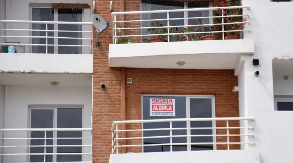 Fachada de prédio com anúncio de aluguel em espanhol