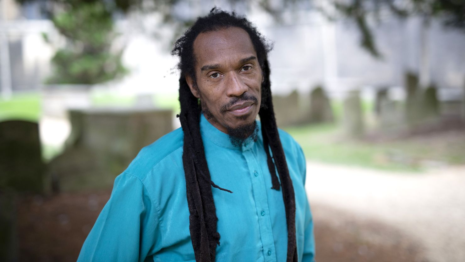 Benjamin Zephaniah de roupa azul, com expressão triste