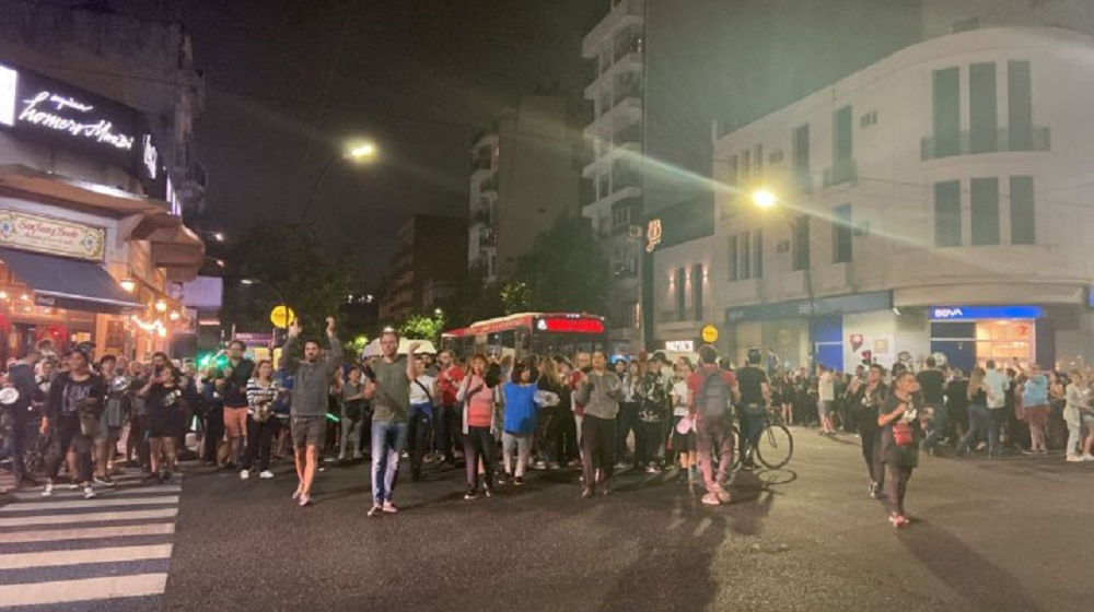 Pessoas nas ruas de Buenos Aires à noite, em protesto
