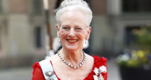 Margrethe II sorrindo, de roupa vermelha