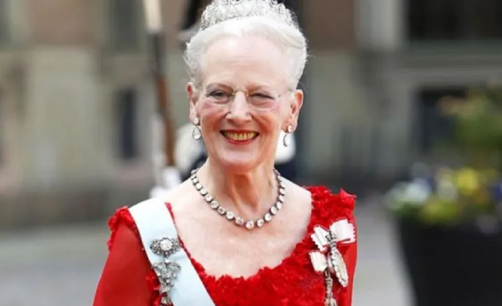 Margrethe II sorrindo, de roupa vermelha