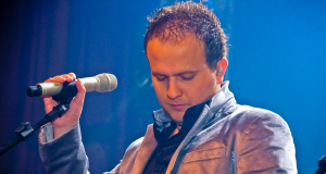 Matheus Possebon olhando para baixo e segurando microfone
