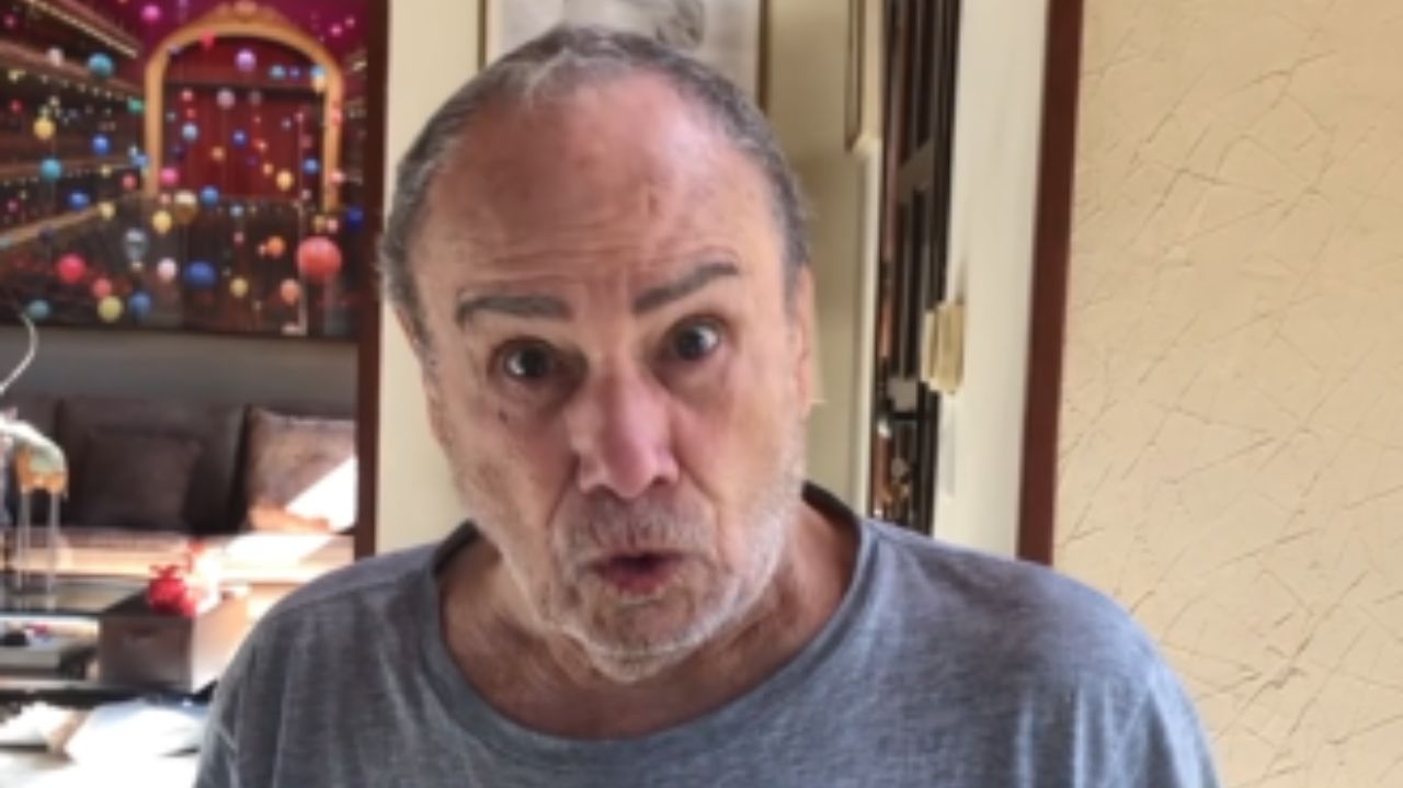 Stênio Garcia de roupa cinza, falando com expressão assustada