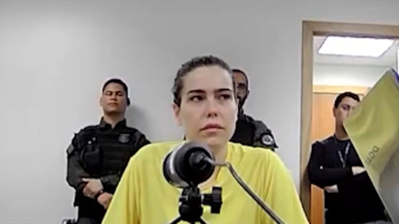 Amanda Partato com expressão triste e camiseta amarela, com cabelo preso