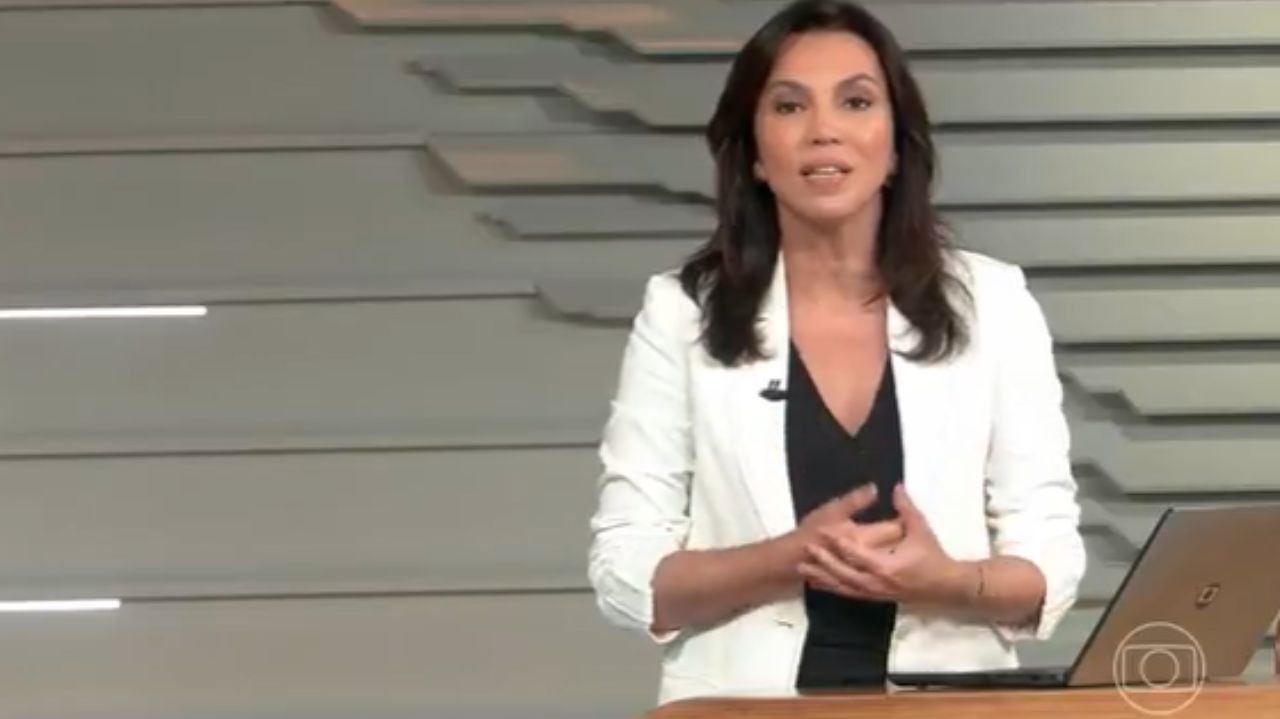 Ana Paula Araújo com expressão séria e roupa branca no estúdio do Bom Dia Brasil