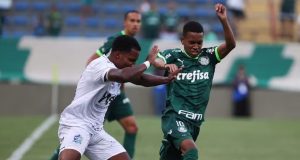 Jogador do Aster disputando com jogadores do Palmeiras em campo