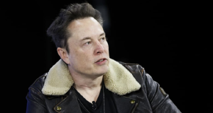 Elon Musk de roupa de frio olhando para o lado com expressão séria