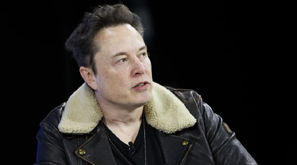 Elon Musk de roupa de frio olhando para o lado com expressão séria