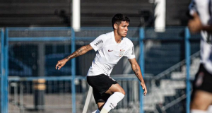 Dimas Candido correndo em campo com bola e uniforme do Corinthians