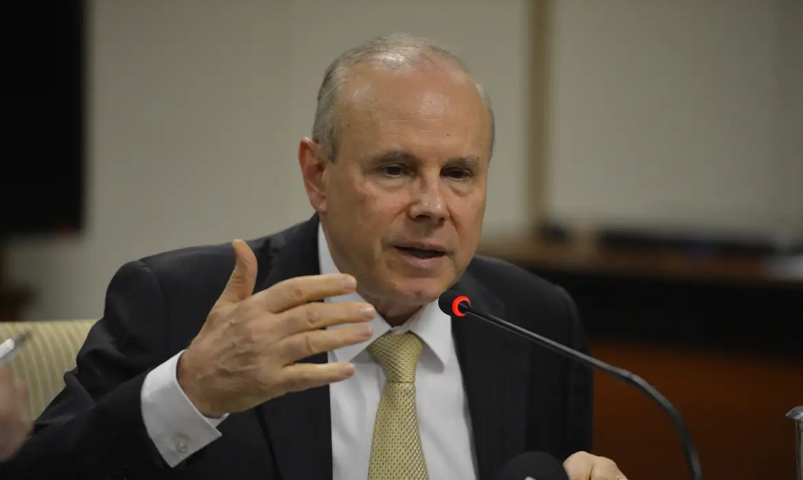 Guido Mantega falando em microfone e gesticulando