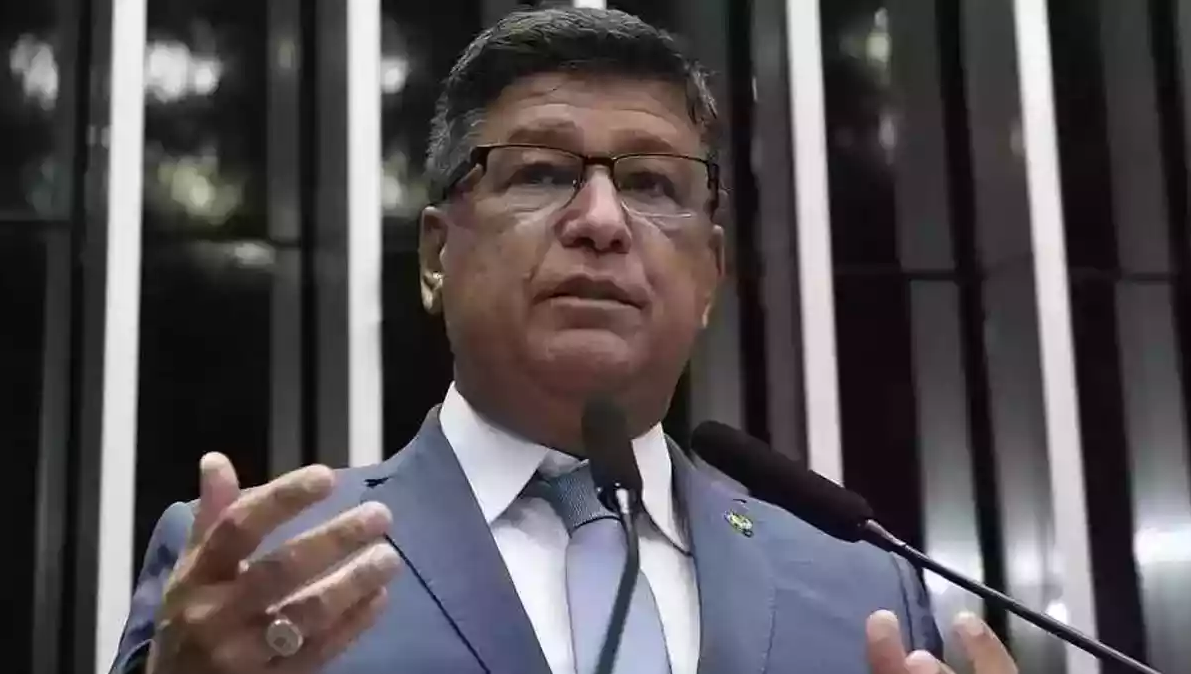 Carlos Viana falando e gesticulando, de óculos e roupa cinza