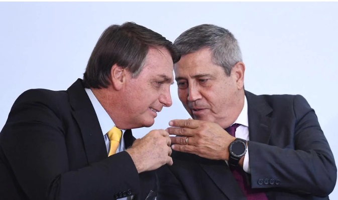 Jair Bolsonaro e General Braga Netto cochichando com expressões de riso e rostos próximos
