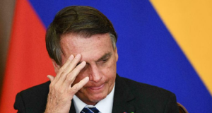 Jair Bolsonaro com cabeça abaixada e expressão de preocupação