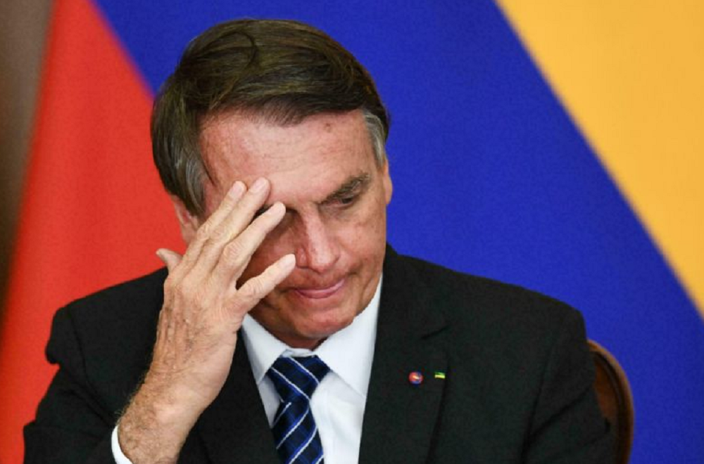 Jair Bolsonaro com cabeça abaixada e expressão de preocupação