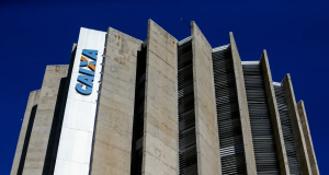 Topo de prédio da Caixa Econômica Federal com céu azul no fundo