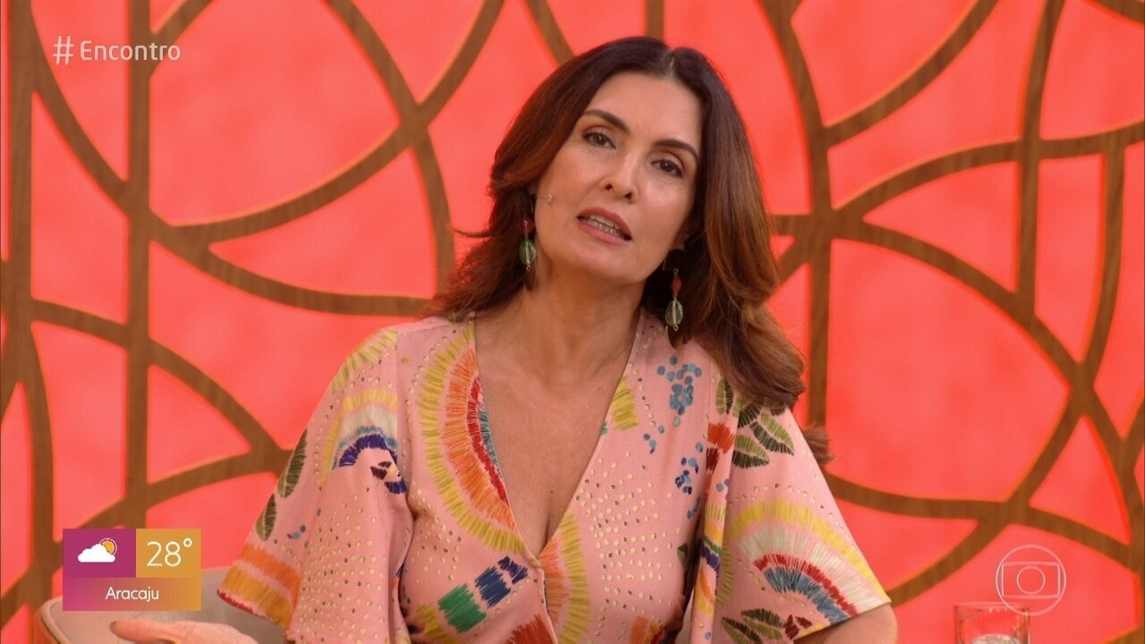 Fátima Bernardes no cenário do Encontro, de roupa colorida, cabelo solto e falando com expressão séria
