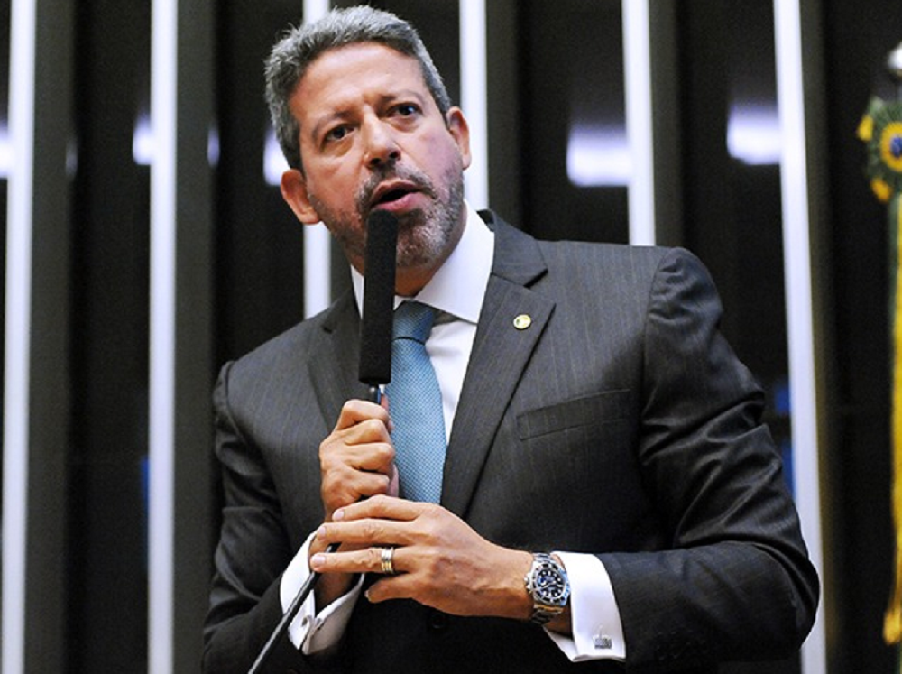Arthur Lira falando em microfone com expressão séria