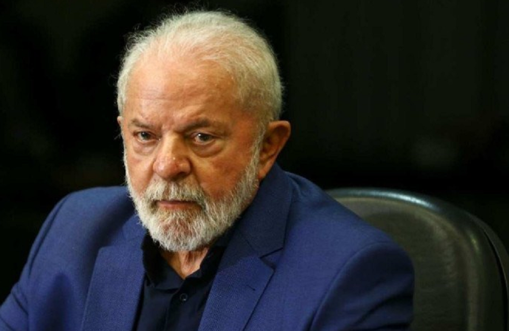 Lula de roupa azul e preta, com expressão séria