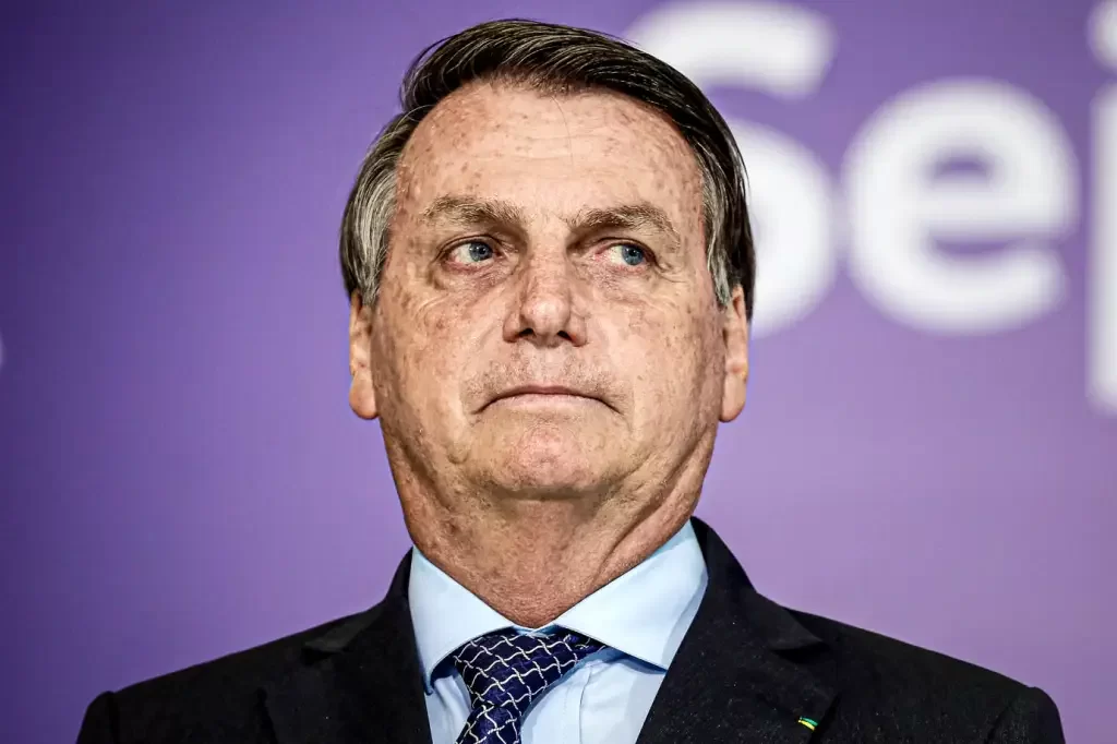Jair Bolsonaro de terno e gravata, com expressão séria