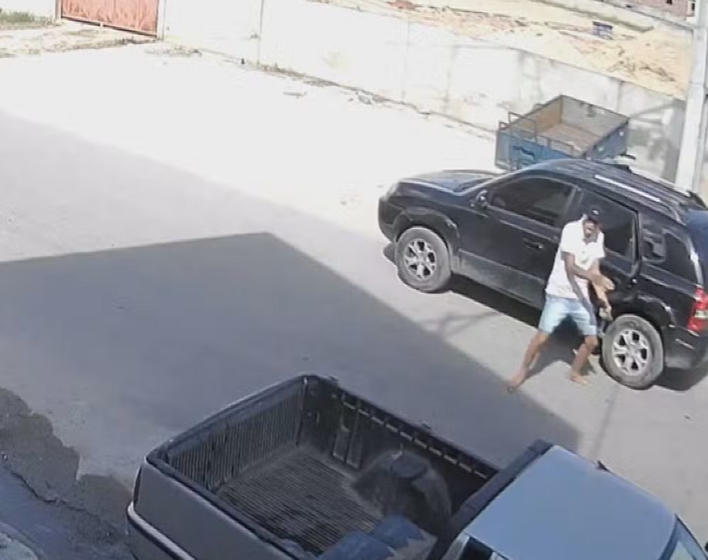 Homem em pé perto de carro em imagem de câmera de segurança