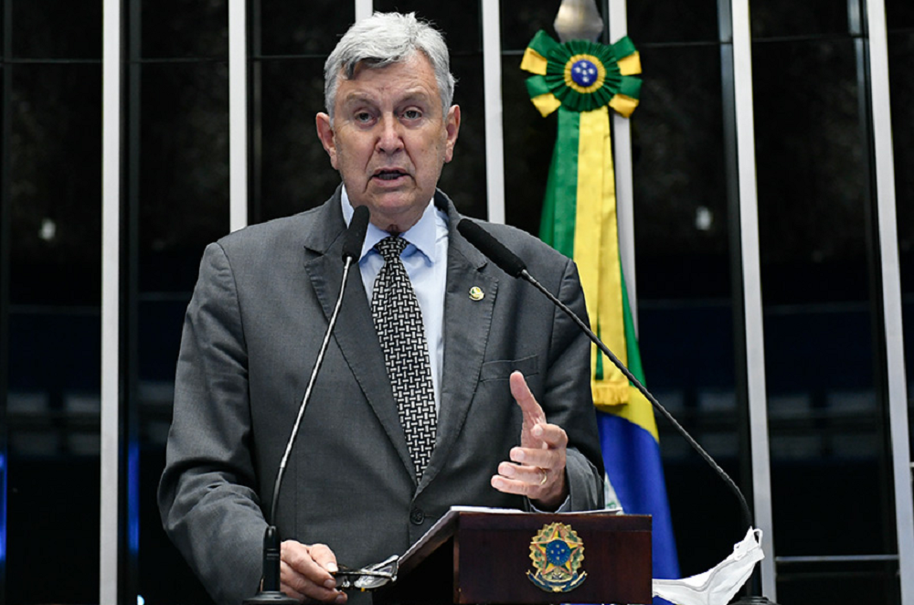 Luiz Carlos Heinze falando em microfone com expressão séria