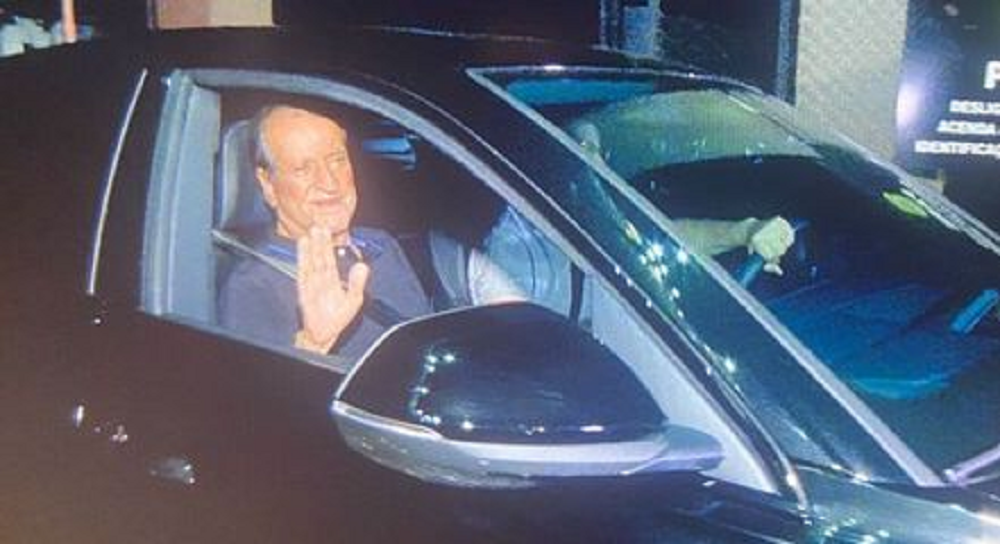 Valdemar Costa Neto sorrindo e acenando dentro de carro