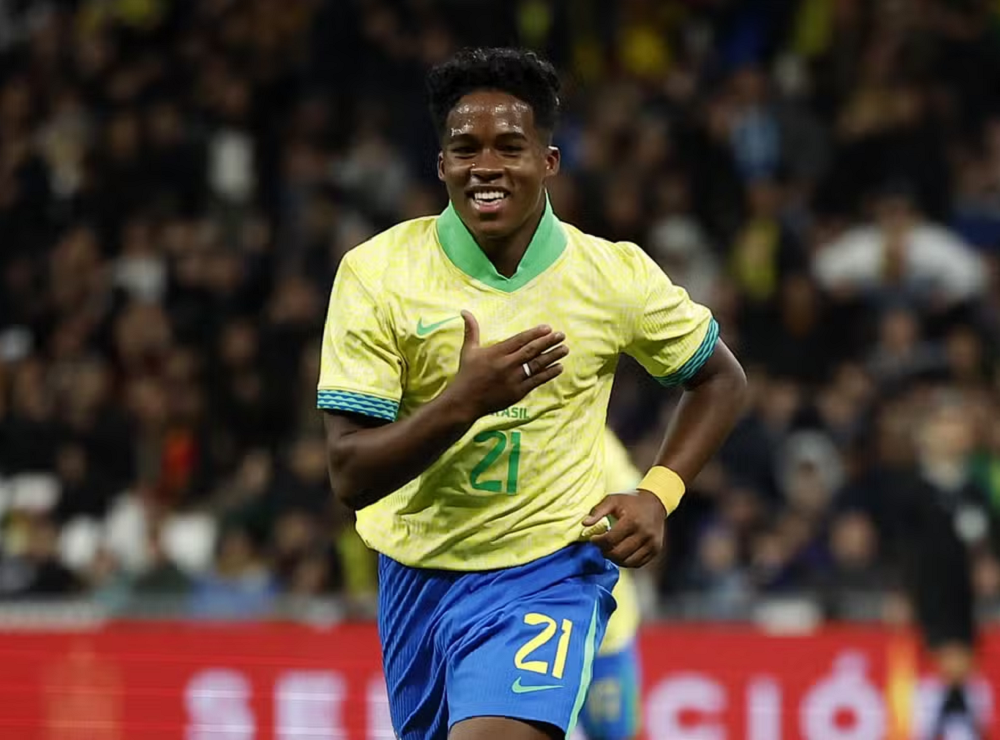 Endrick correndo com uniforme da seleção brasileira, sorrindo