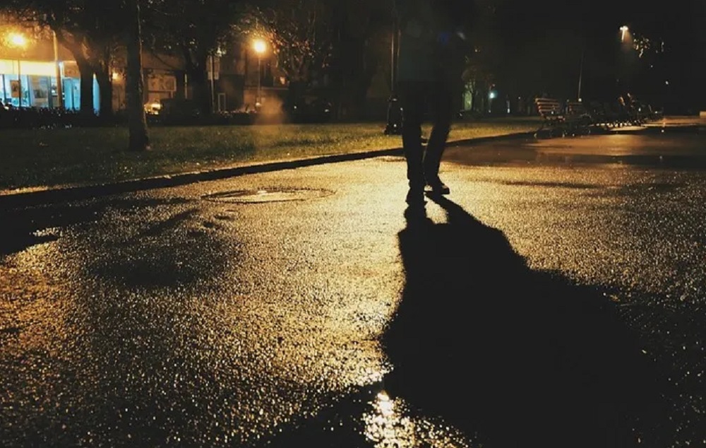 Imagens de pernas em rua deserta, à noite