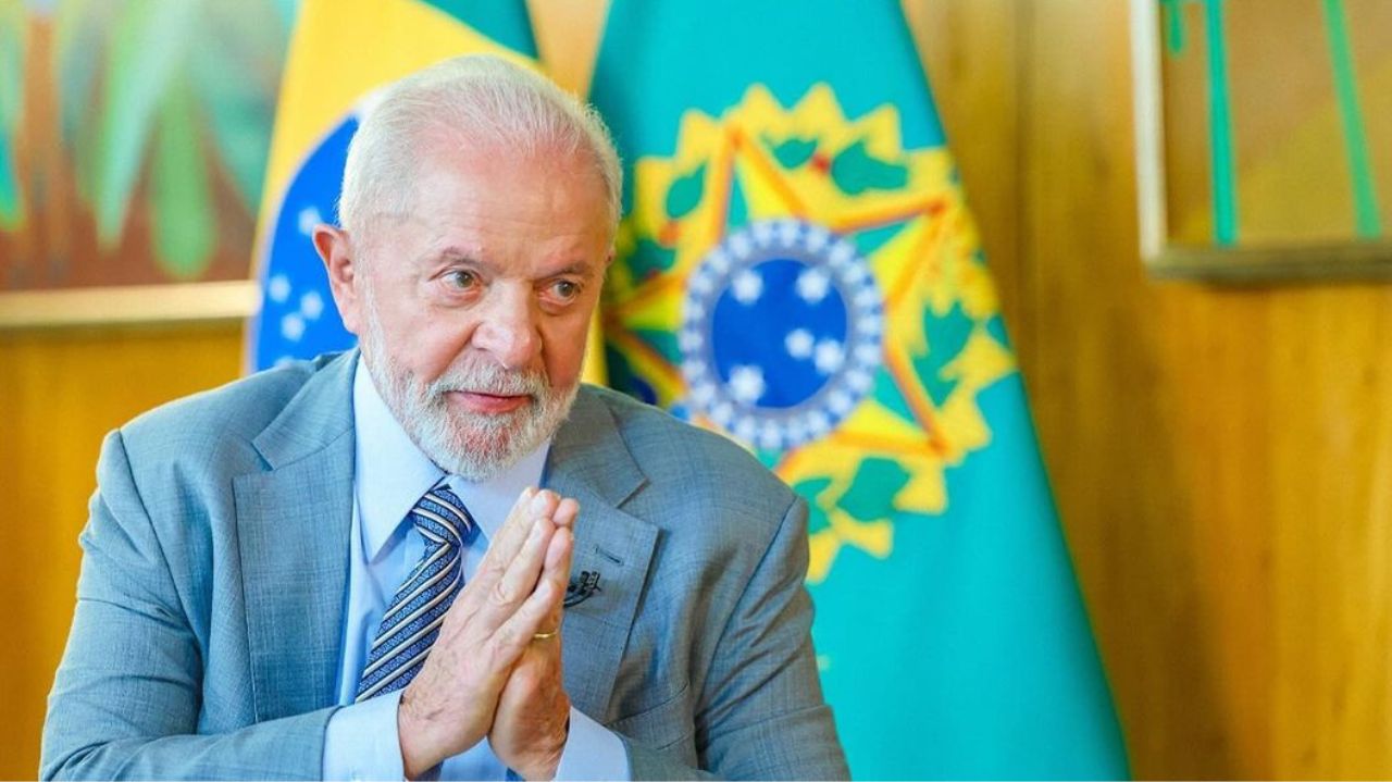 Lula com expressão séria, fazendo sinal de agradecimento