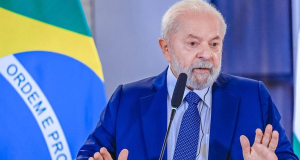 Lula falando e gesticulando com expressão séria e roupa social azul