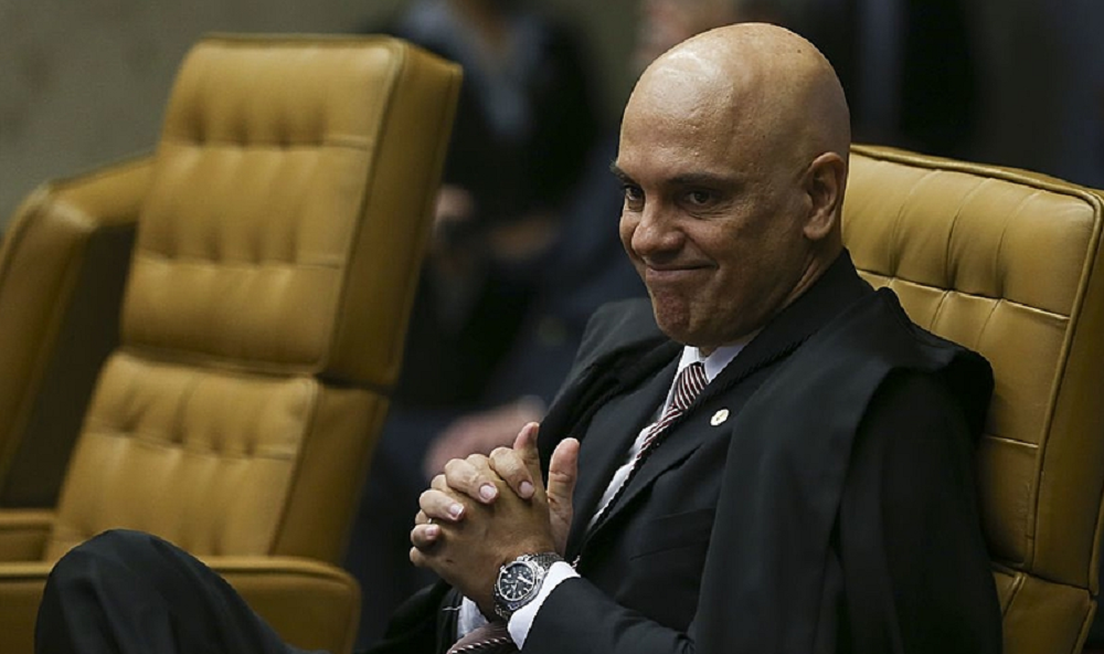 Alexandre de Moraes sentado, com expressão de satisfação