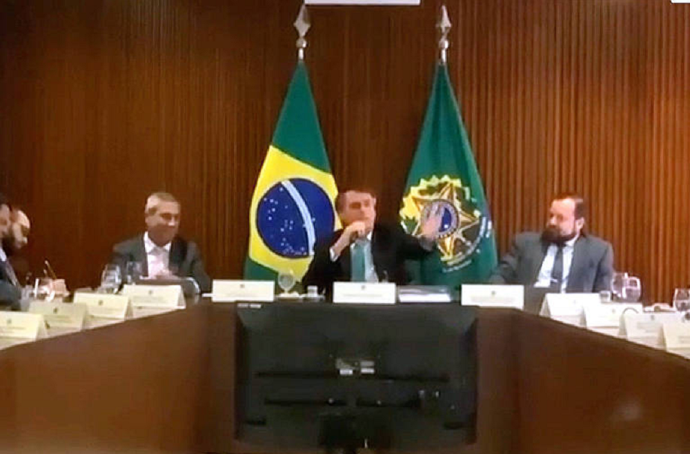 Jair Bolsonaro sentado, falando em reunião