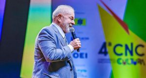 Lula de perfil, falando em microfone durante evento