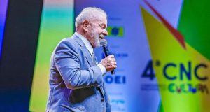 Lula de perfil, falando em microfone durante evento