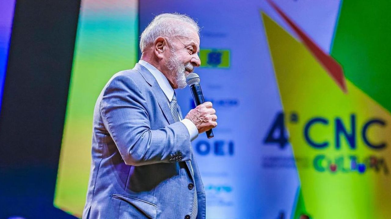 Lula de perfil, falando em microfone durante evento