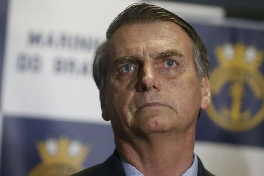 Jair Bolsonaro com expressão de tristeza, sem olhar para a câmera, em close